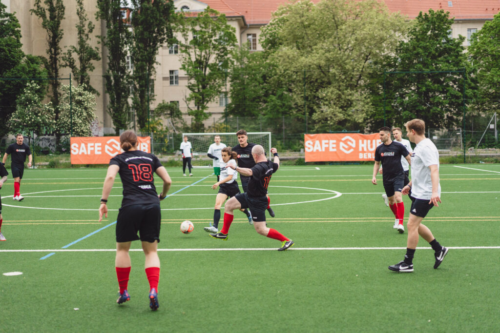 Menschen spielen Fußball auf dem Sportplatz des Safe-Hub Berlin