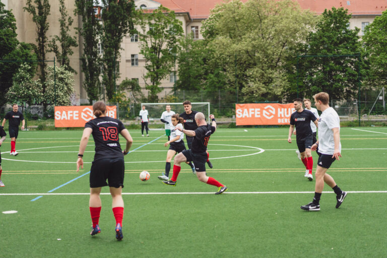 Menschen spielen Fußball auf dem Sportplatz des Safe-Hub Berlin